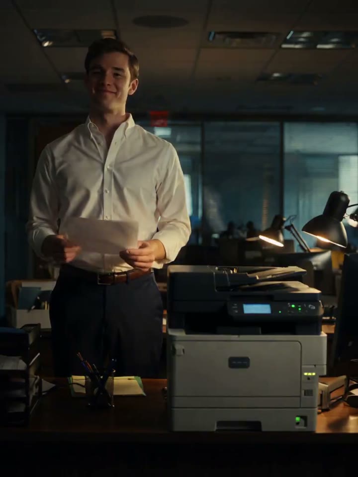 An exhausted office printer facing a cheerful employee after hours